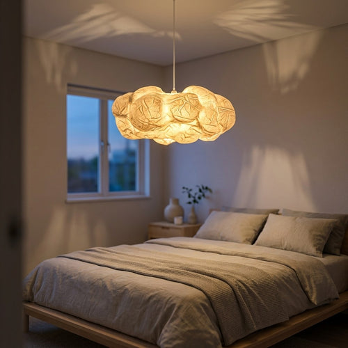 Cloud Pendant Light glowing warm white above a bed in a minimalist bedroom