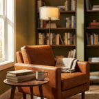 Reading nook scene: lamp beside a cognac leather armchair with books