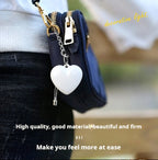 Heart shaped purse light clipped to small handbag