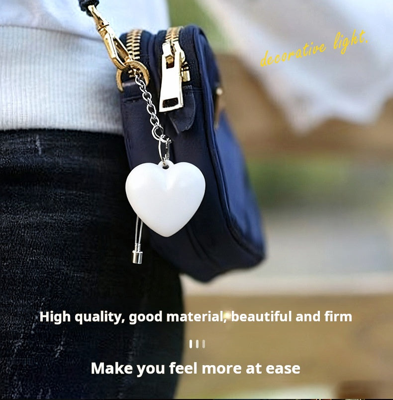 Heart shaped purse light clipped to small handbag